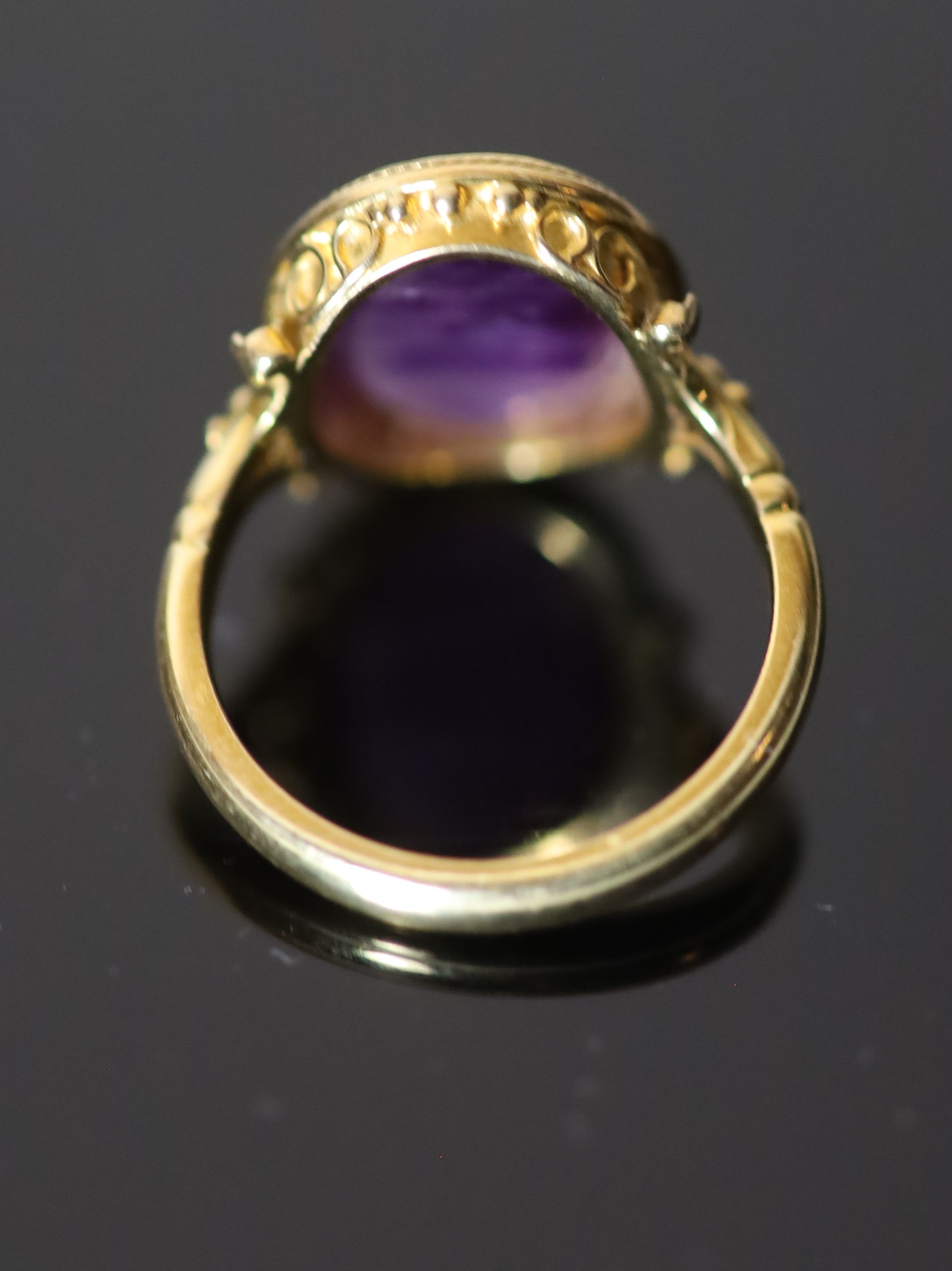 A 19th century style gold ring set with an antique intaglio oval amethyst,